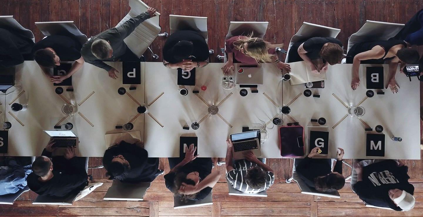 A Mesa team working together around a long table